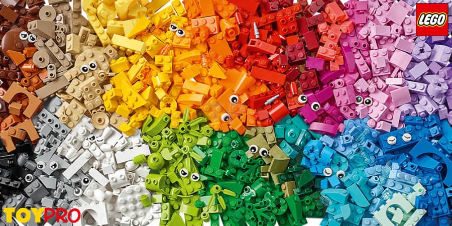 Vibrant LEGO bricks arranged in a rainbow gradient, featuring several pieces with printed eyes.