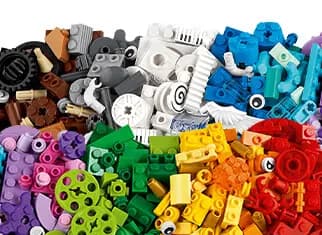 Assorted building bricks and specialty pieces organized into a vibrant pile of color-coded sections.